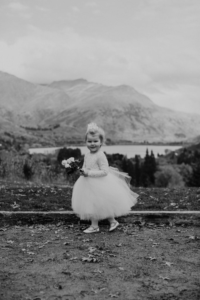 New Zealand wedding with an Anagrassia flower girl wearing Communion alencon lace and champagne tulle Communion style dress with long sleeves and satin buttons