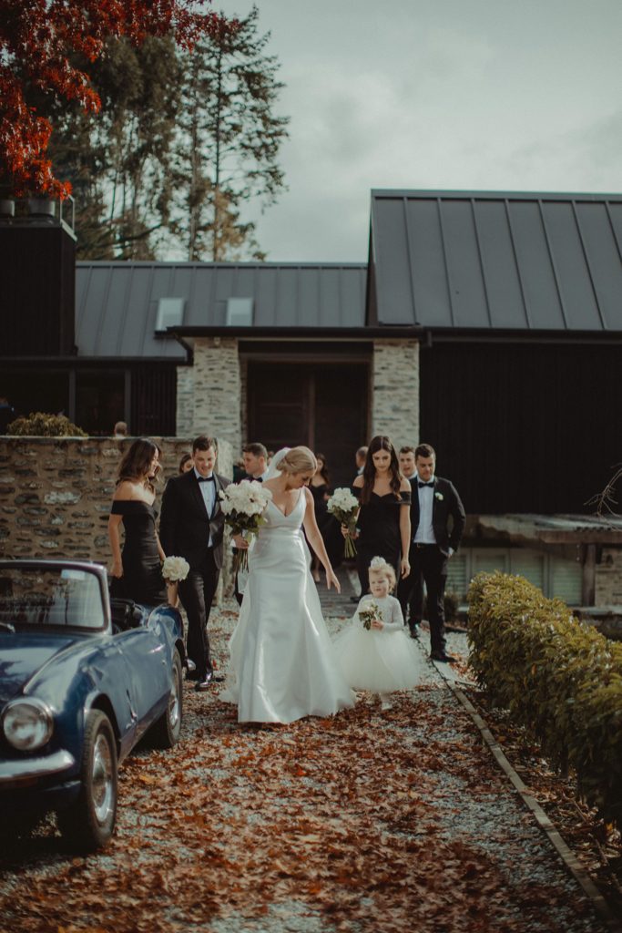 New Zealand wedding with an Anagrassia flower girl wearing Communion alencon lace and champagne tulle Communion style dress with long sleeves and satin buttons