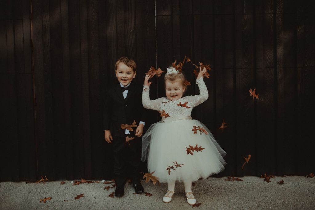 New Zealand wedding with an Anagrassia flower girl wearing Communion alencon lace and champagne tulle Communion style dress with long sleeves and satin buttons