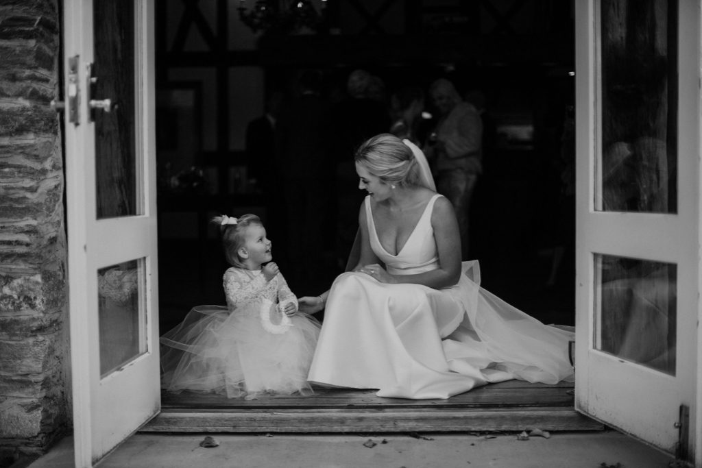 New Zealand wedding with an Anagrassia flower girl wearing Communion alencon lace and champagne tulle Communion style dress with long sleeves and satin buttons