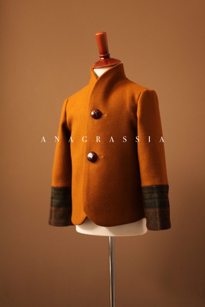 A gold wool jacket blazer with color block lumbarjack tweed cuffs, collar, and leather buttons by luxury childrenswear brand and emerging designer, Anagrassia.