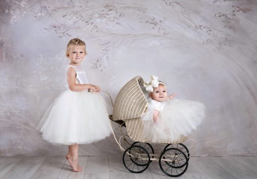 Flower girls in dresses and riding wedding cart wagon