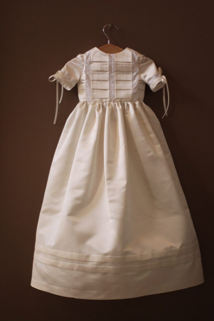 A long silk christening gown with heirloom pleating and lace inserts