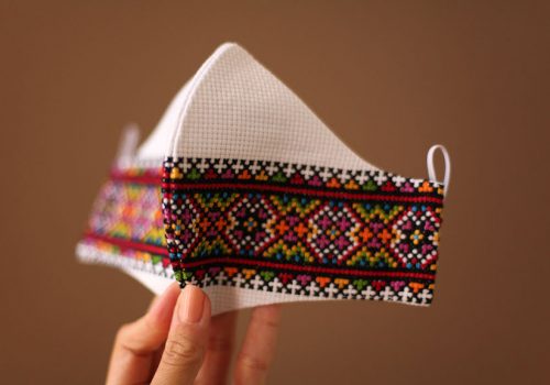 Woman holding a Ukrainian hand embroidered face mask